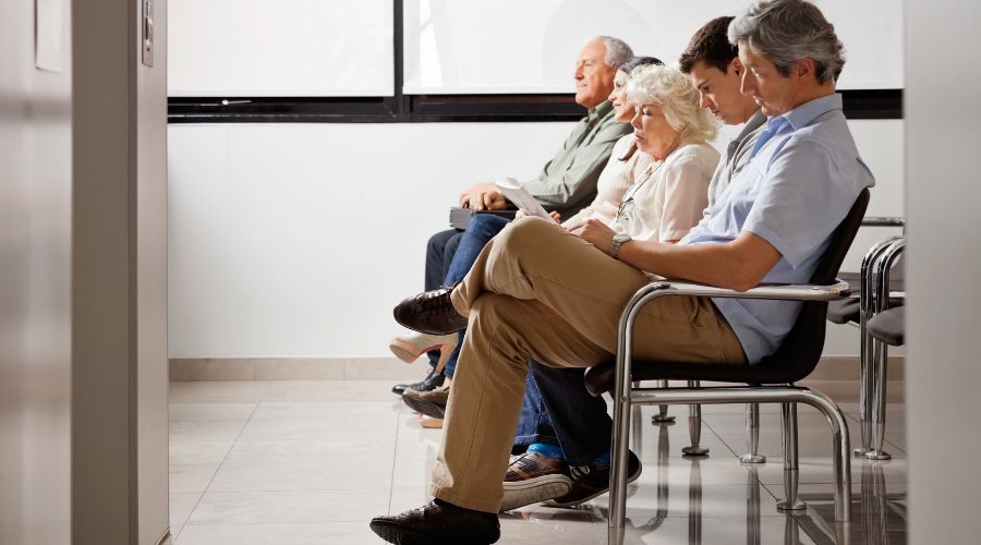 cinque persone sedute in una sala d'attesa medica 
